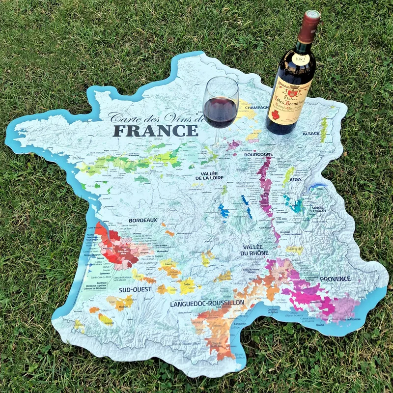 Carte des vins de France de 120 cm posée sur l’herbe avec une bouteille de vin
