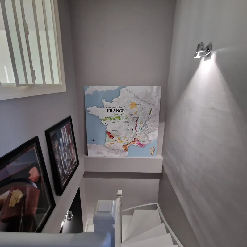 Grande carte des vins carrée en décoration murale dans un escalier éclairé